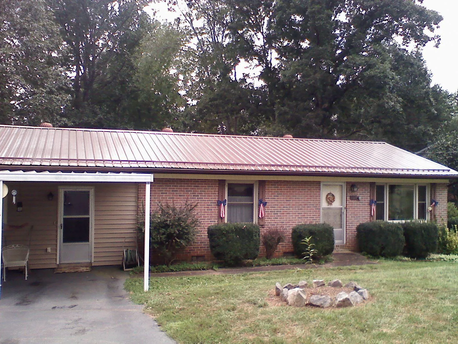 Bronze metal roof and carport on a brick ranch home — Roof Repair work by our crew in Beech Creek